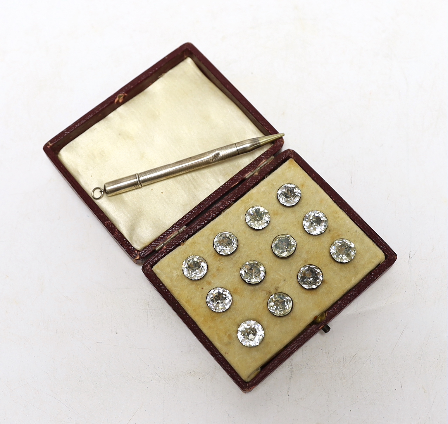 A boxed set of paste buttons and a silver pencil